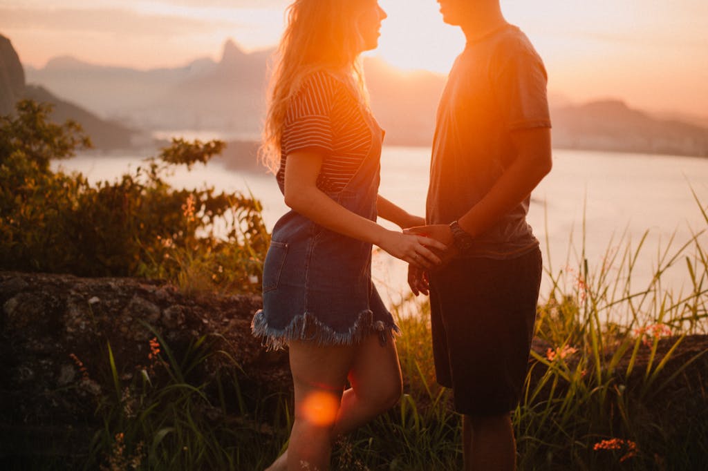 A couple enjoys a romantic sunset overlooking Rio's skyline in Jurujuba, Brazil.